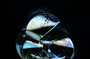 Soap bubble close up isolated on black background photo