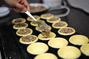 Chef cooking pie from meat and mushrooms in kitchen photo