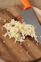 Chopped garlic in wooden tray on table photo