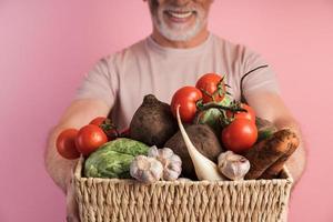 Cerrar vista, canasta con verduras, hombre sujetando verduras frescas foto