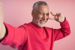 Positive man shows V sign, gesture of victory, peace photo