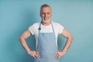 Older, elderly man with his hair and beard wears an apron photo