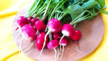 Ripe juicy radish roots lie on a cutting board photo