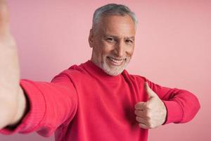 atractivo, anciano tomando una selfie, pulgar hacia arriba, todo está bien foto