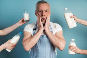 Surprised man touches his face with his hands, he wears an apron photo