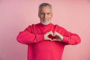 Older man shows a gesture from the heart photo