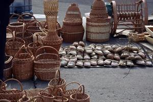 Sale of baskets of willow twigs and wicker bast shoes photo