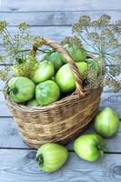 A wicker basket with green tomatoes photo