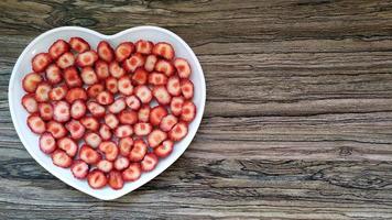 The sliced strawberries are in a heart-shaped plate photo