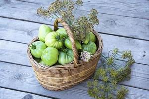 Vegetables in a wicker basket on a wooden background photo