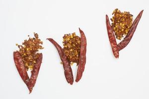 Dried red pepper flakes isolated on white, top view photo