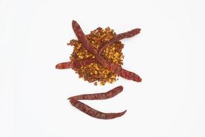 Dried red pepper flakes isolated on white, top view photo