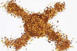Dried red pepper flakes isolated on white, top view photo
