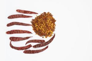 Dried red pepper flakes isolated on white, top view photo