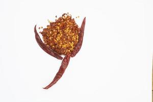 Dried red pepper flakes isolated on white, top view photo