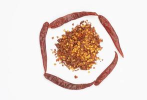 Dried red pepper flakes isolated on white, top view photo