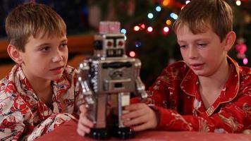 Boys playing with classic toy robot on Christmas video