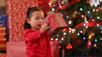 Young girl shaking Christmas gift