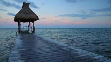 Woman walks down pier at tropical resort video