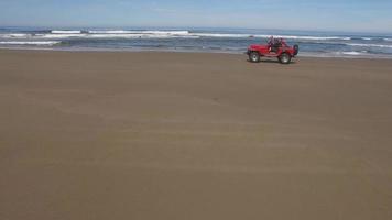 prise de vue aérienne d'un véhicule tout terrain 4x4 roulant sur la plage video