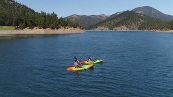 Aerial drone shot of couple kayaking on lake video
