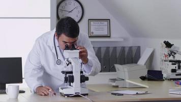 vétérinaire à l'aide d'un microscope in office video