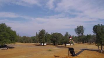 piloto de motocross yendo de gran salto, cámara lenta, tiro 4k en rojo épico video