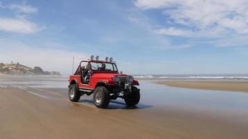 coppia alla guida di un fuoristrada 4x4 che guida sulla spiaggia video