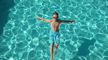 menino jogando água na piscina em câmera lenta, baleado no phantom flex 4k video