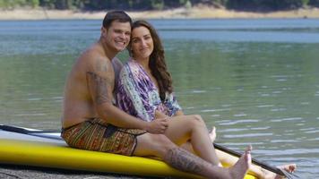 retrato de casal à beira do lago com pranchas de stand up paddle video
