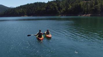 Aerial drone shot of couple kayaking on lake video