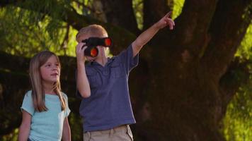 due bambini che guardano attraverso il binocolo video