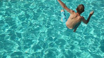 Junge, der in Zeitlupe in den Pool spritzt, aufgenommen auf Phantom Flex 4k video