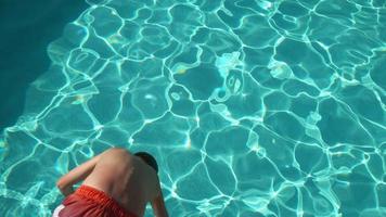 menino jogando água na piscina em câmera lenta, baleado no phantom flex 4k video