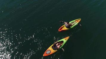 Aerial drone shot of couple kayaking on lake video