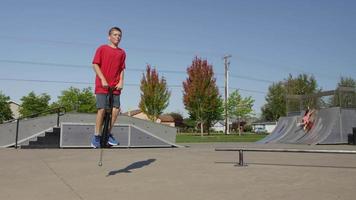 jongen springt op pogo stick in park video