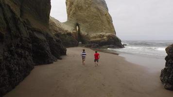 twee jongens rennen op het strand video