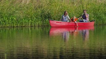 família remando canoa no lago video