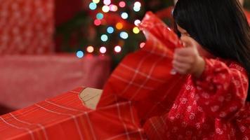 Young girl tearing paper off Christmas present video