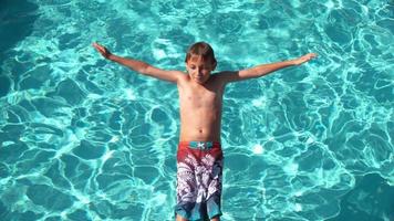 menino jogando água na piscina em câmera lenta, baleado no phantom flex 4k video