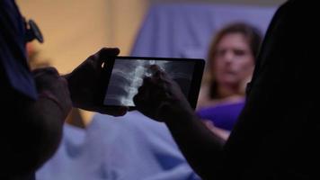 Los médicos miran rayos X en tableta digital. video