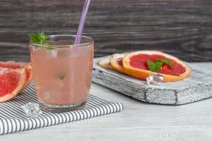 Cocktail with grapefruit on a light background with a sprig of mint photo