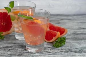 Cocktail with grapefruit on a light background with a sprig of mint photo