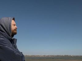 man hipster with a beard and mustache in the hood photo