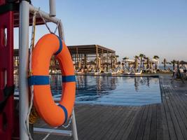 Aro salvavidas naranja cerca de la piscina pública sobre un fondo borroso foto