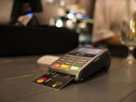 close up payment machine on the table for paying bill by at table photo