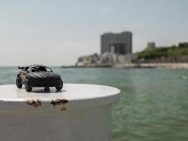 Modelo de coche de juguete en negro con el fondo del mar foto