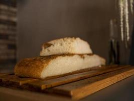 ciabatta en forma cortada sobre una superficie de madera. pan italiano foto