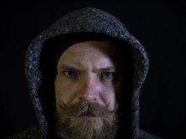 portrait of a man with a beard and mustache in the hood photo