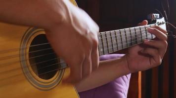 Musician playing the guitar at home video